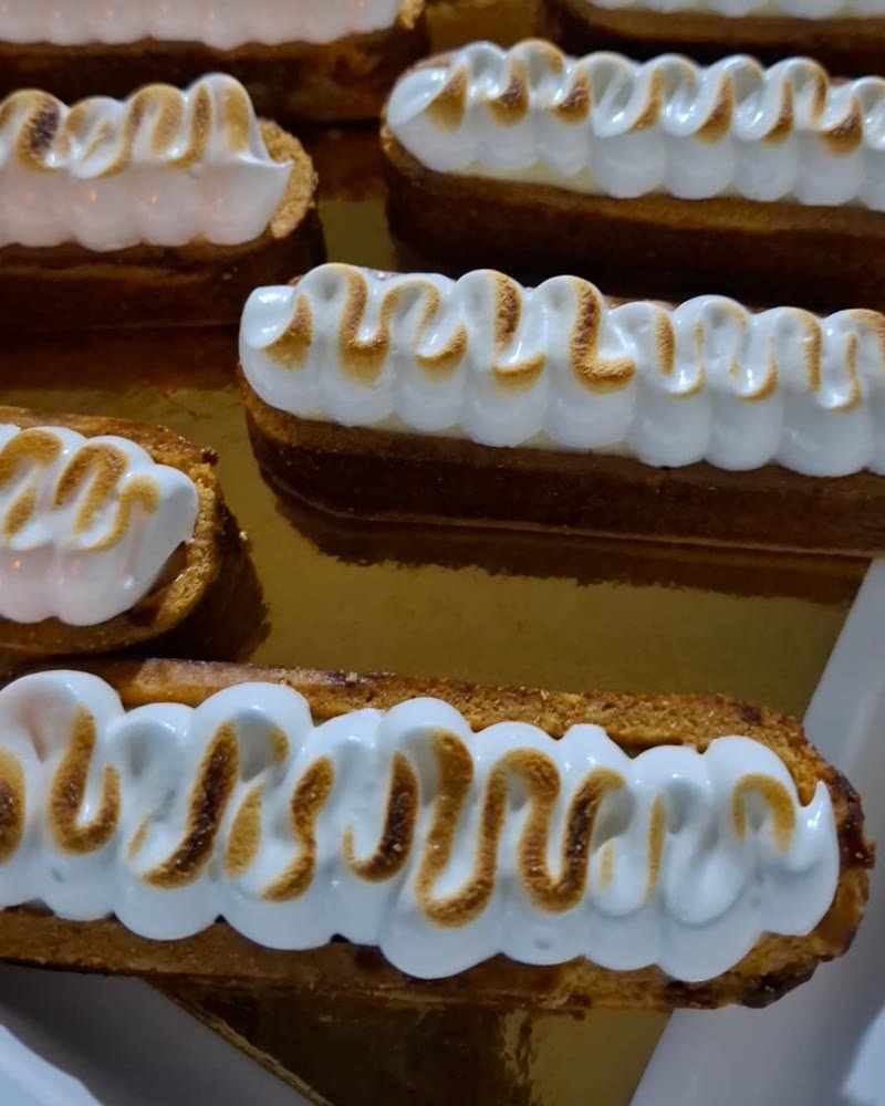 Tartelettes meringuées dorées au chalumeau, rangées sur un plateau